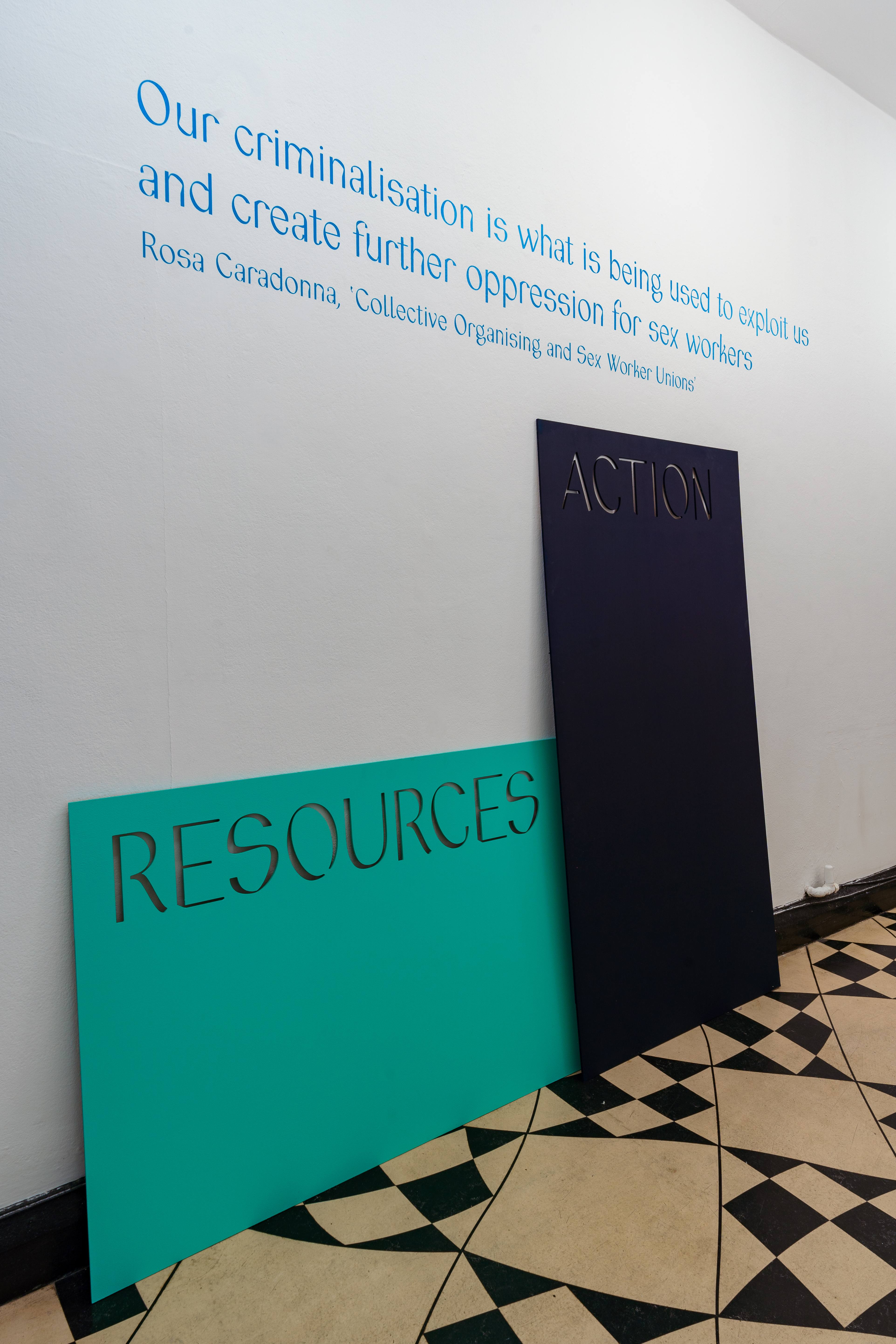 A white wall features the text 